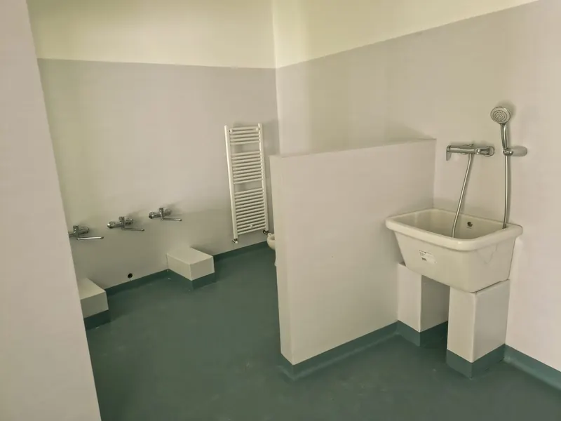 Bagno d'asilo con lavatoio e pavimento verde acqua