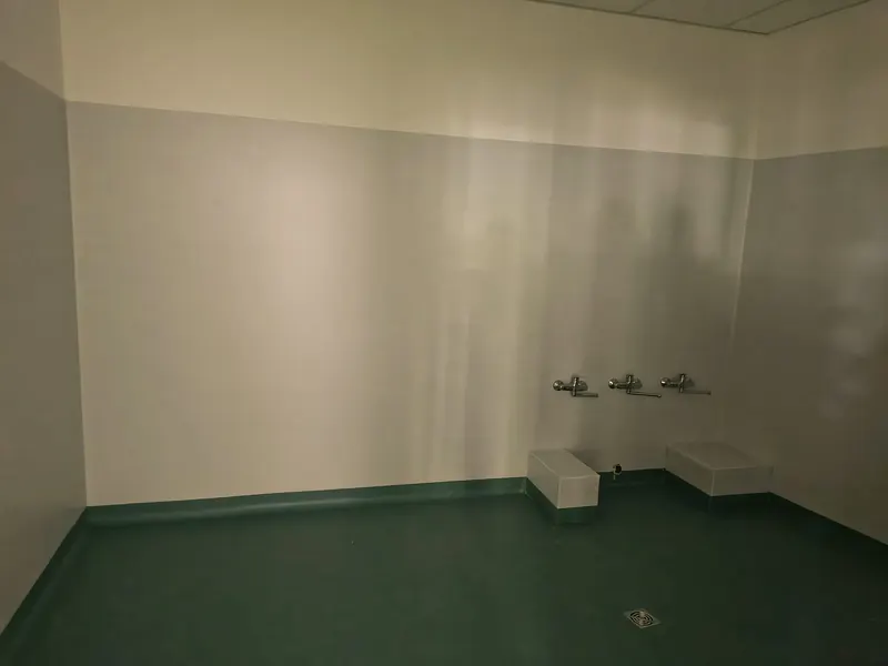 Bagno d'asilo con rubinetti bassi e pavimento verde acqua