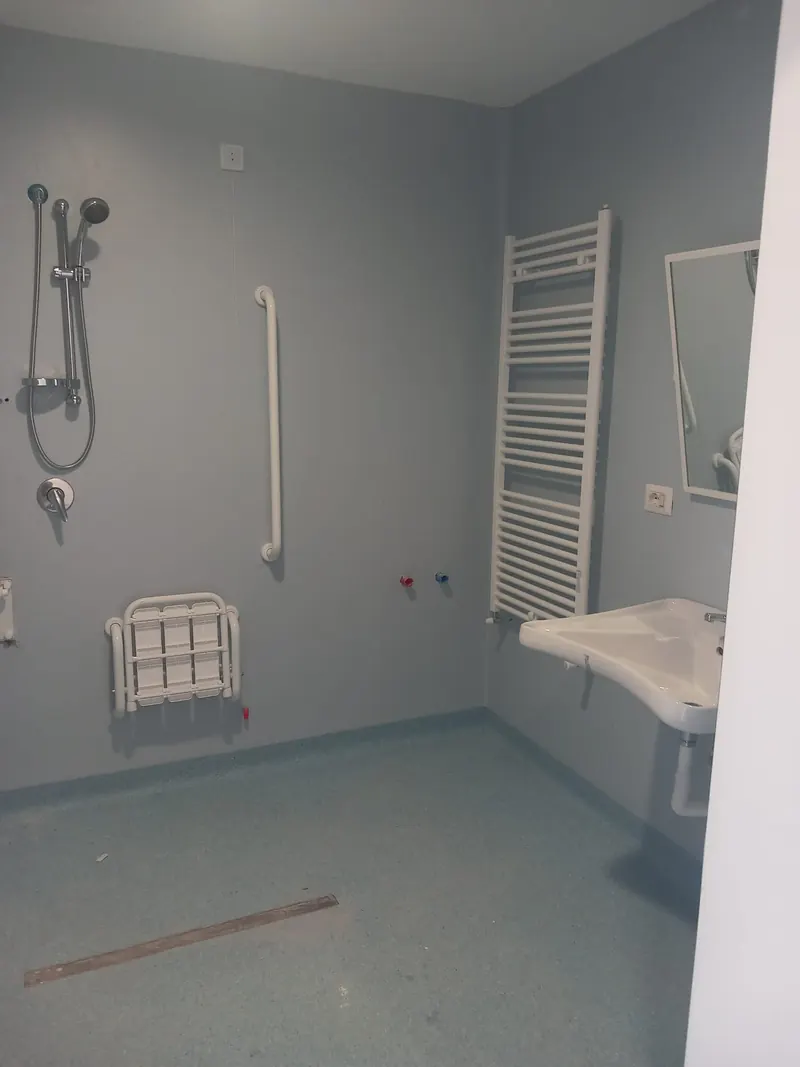 Bagno per disabili con pavimento in PVC granigliato azzurro