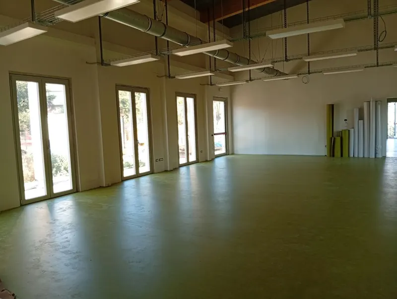 Open space in linoleum verde con i teli arrotolati in fondo