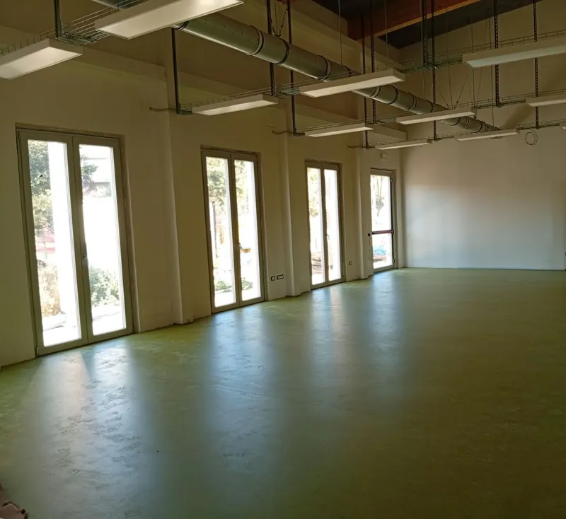 Grande sala con vetrate e pavimento in linoleum verde