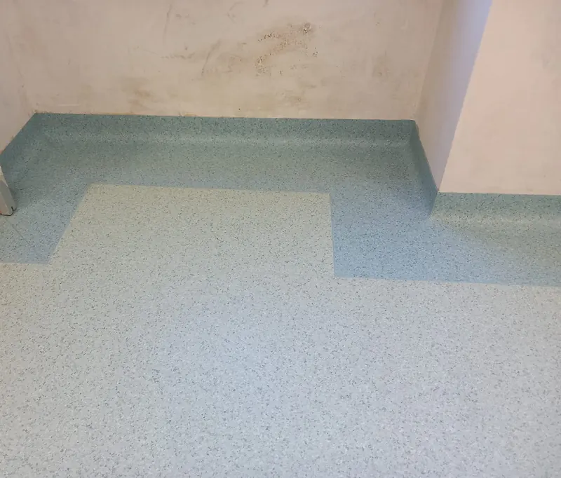 Locale con PVC granigliato a due toni e bordo raccordato al muro