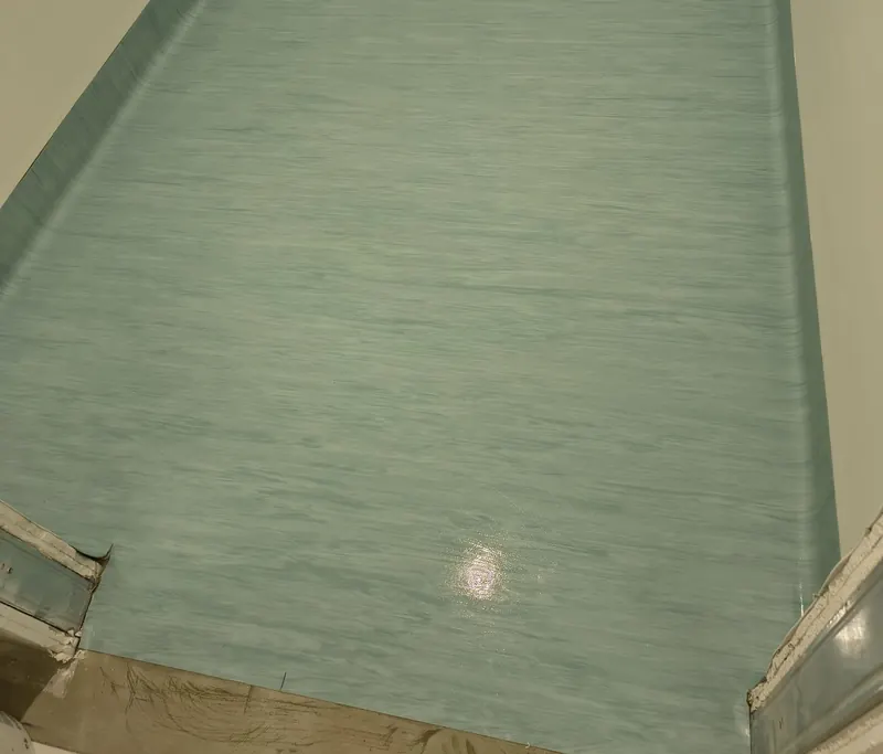 Pavimento in PVC liscio verde acqua con risvolto alla parete