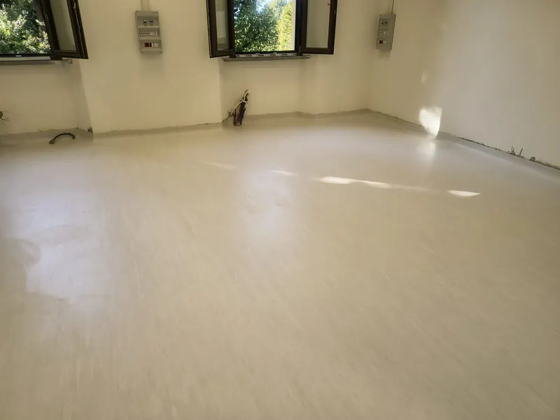 Sala ampia e luminosa con pavimento in PVC chiaro