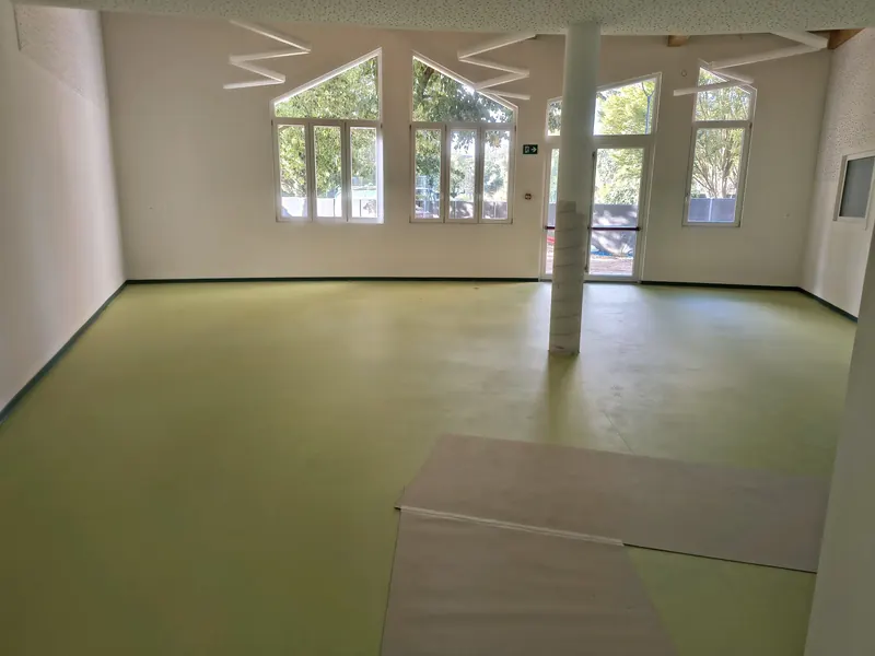Salone di una scuola con pavimento in linoleum verde