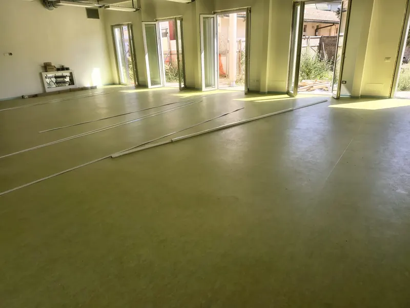 Salone con vetrate e linoleum verde