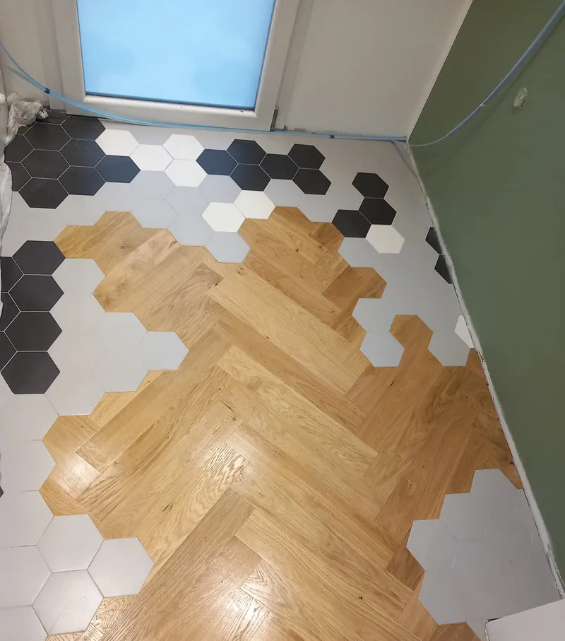 Parquet a spina di pesce in rovere fra esagonette di ceramica