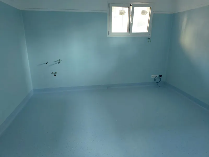 Stanza d'ospedale con pavimento e pareti rivestiti in PVC azzurro