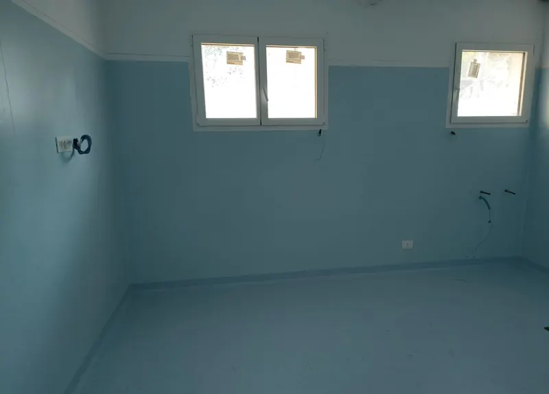 Stanza in PVC azzurro, dal pavimento alla fascia bianca delle pareti