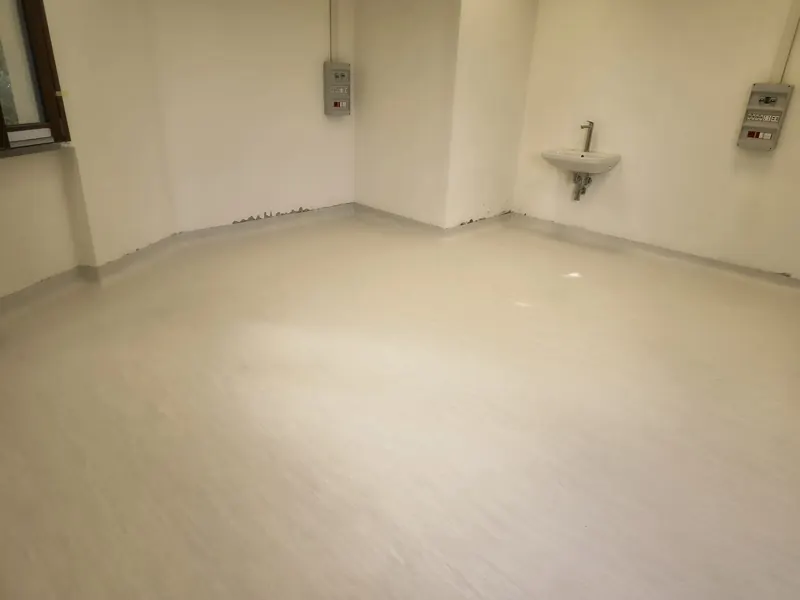 Stanza con pavimento chiaro e raccordo a sguscio